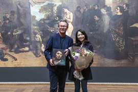 Leopold Museum-Direktor Hans-Peter Wipplinger gratuliert Yuki Aoki, der 100.000. Besucherin der Ausstellung Gustave Courbet. Realist und Rebell vor der Reproduktion von Gustave Courbets gro�formatigen Gem�lde 