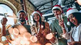 Menschen mit Wiehnachtsmannm�tzen und Sektgl�sern bei einer Weihnachtsfeier