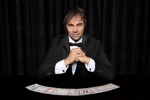 Lucca Lucian an einem Tisch mit aufgelegten Spielkarten
