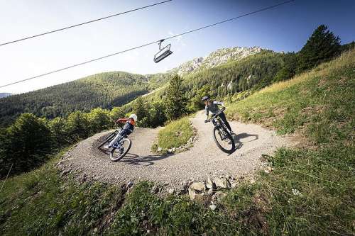 Zwei Radfahrer in einer Kurve im Alpen-Bikepark Schneeberg