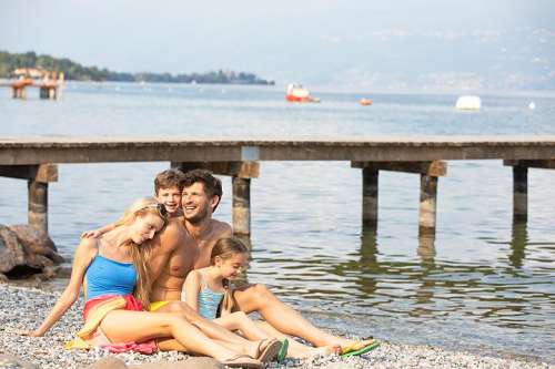 Zwei Erwachsene und zwei Kinder am Strand von Europa Silvella Camping Village