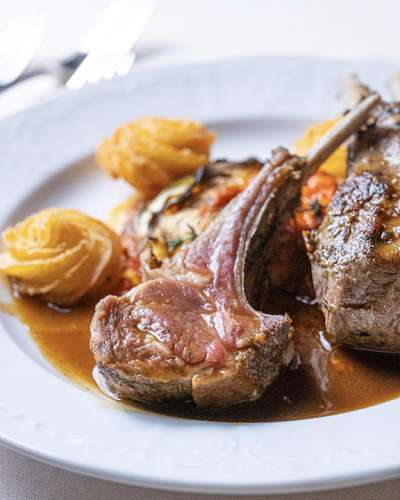 Aus dem Men�: k�stlich angerichtete Lammkoteletts mit Rattatouille